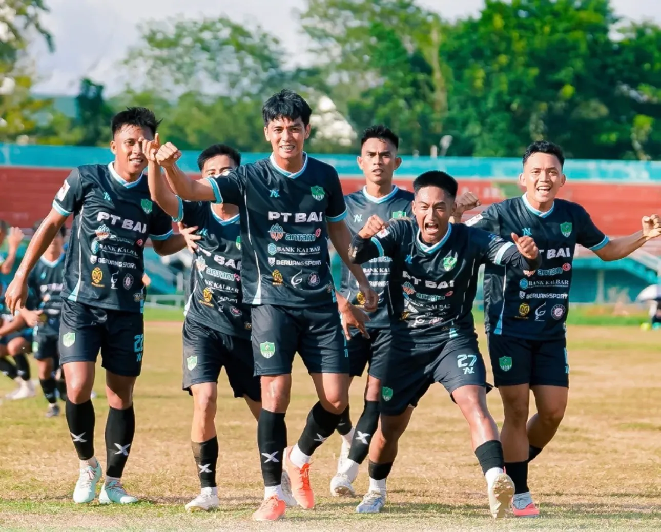 Pemain sepak bola merayakan bersama dengan kit NOIR mereka.